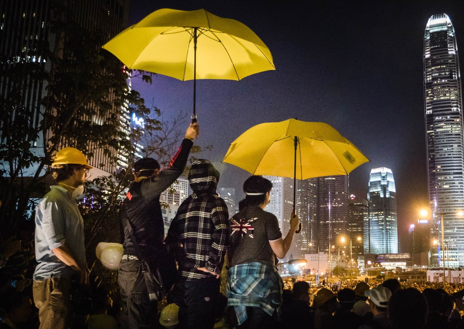 People holding up a yellow umbrella in Hong Kong