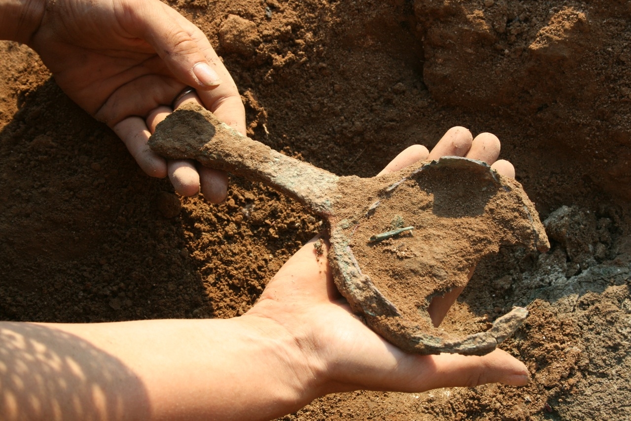 person holding a spoon that was buried in the dirt